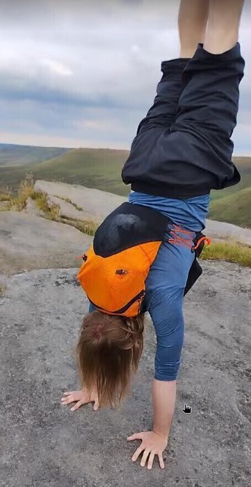 Person doing a handstand while wearing the backpack